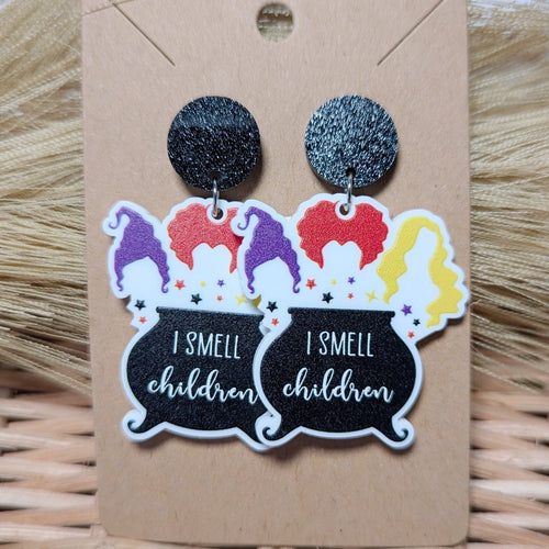 Dangle earrings with the 3 witches from hocus pocus and a cauldron that says I smell children