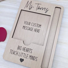 Load image into Gallery viewer, Wooden sticky note holder that also has a slot for a pen. A custom note and name are shown engraved on the piece along with the quote &quot;Big hearts teach little minds&quot;
