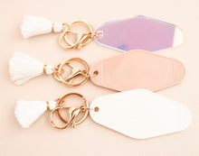 Load image into Gallery viewer, 3 different colored motel style keychains with tassels. Blush pink, iridescent, and white.
