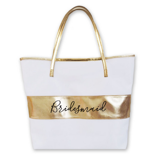 White tote bag with a gold handle and horizontal gold strip on the middle of the body of the bag. The word 
